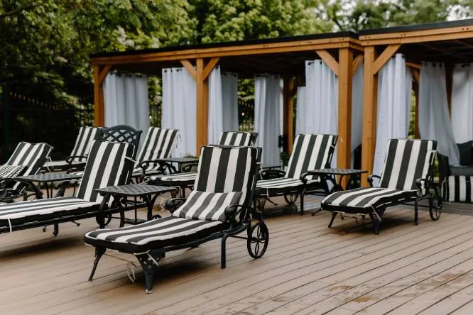 A poolside area with lounge chairs and cabanas.